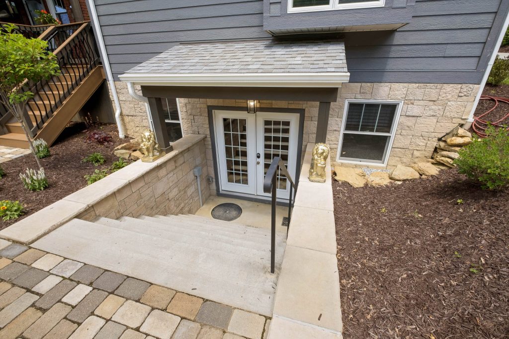 Stairs leading to a white double door walk-out basement entrance.